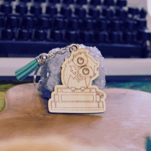 Porte-clé métal illustré d’un hibou perché sur une pile de livres — Verso